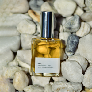'Love' oil perfume captured on a background of white rocks