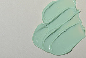 Close-up image revealing the texture of the green moisturiser as it is smeared.